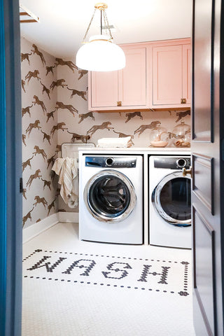 Washer and dryer in a room with animal print wallpaper.