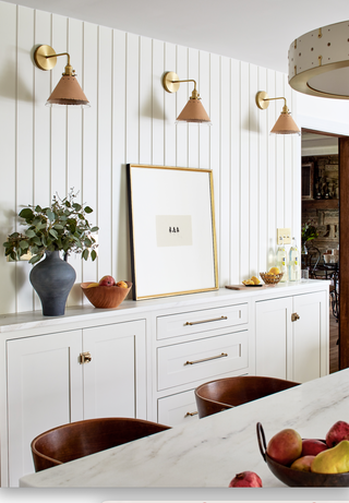 A clean and timeless dining room design with a dining room buffet and modern wall sconces. 