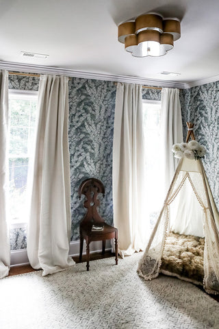 A calming children's bedroom design with blue floral wallpaper and a tent to play in.