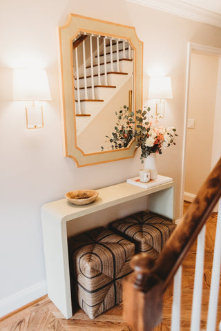 Foyer styling with wall sconce lighting, wall mirrors, and flowers.