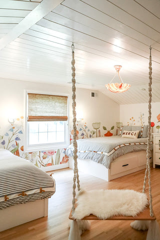 Kids' bedroom design with flower wallpaper and a swing.