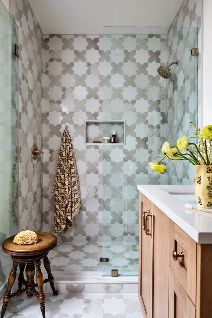 Bathroom with soft blue geometric tile and warm wood vanity — blue coastal interior design by Details + Design.